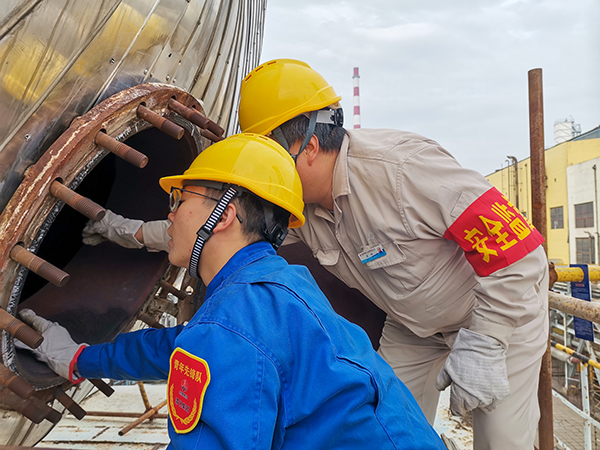 10月17日下午，在52工段除氧器人孔外，屈煒正在給董宇斌講述內(nèi)部構(gòu)造及工作原理。.jpg